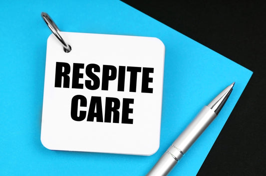 A photo of a keychain tag that says 'Respite Care' on it with a silver ball-point pen laying beside it.